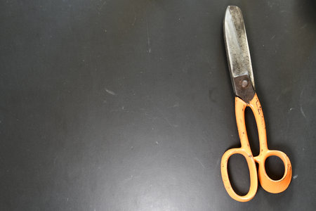 Scissor on Black Desk Background Steel Orange. High quality photoの写真素材