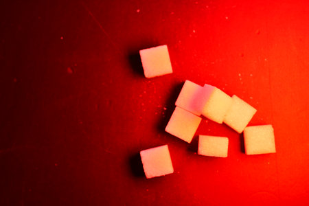 Sugar cubes background red iluminated sweet food. High quality photo