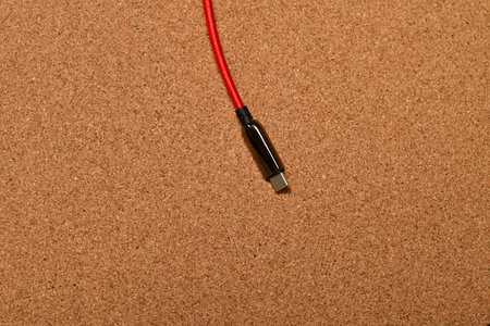 USB C Cable red with black blug on cork surface. High quality photo