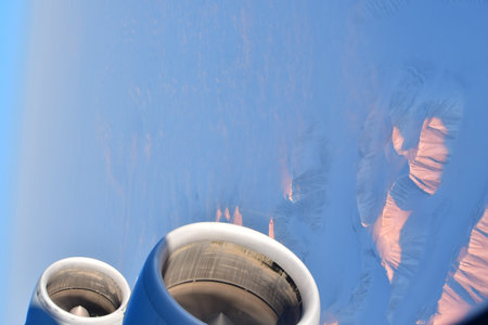 View of Greenland from Jet Plain Window in Winter Nature cold ice Mountains Jet Engine Wing. High...