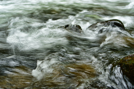 Flowing water in river with rocks natural motion. High quality photoの写真素材