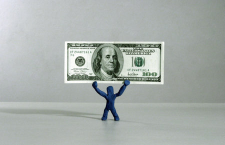 Plasticine man holding 100 dollars bill.の写真素材
