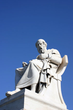 Ancient greek thinker on a postument on blue sky background.の写真素材