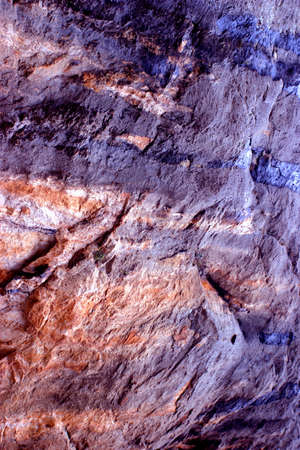 Detail of a rock with colorful mineral layers and veins