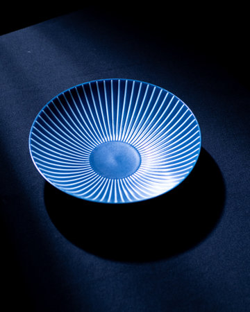 Empty blue plate on a black background. Shallow depth of field.の写真素材