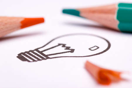 The light bulb is a symbol for creativity, thinking and solution finding. The orange and teal look is popular in art and design in the 21st century. Sketching or drawing techniques are often used while brainstorming or creating a mind map.の写真素材