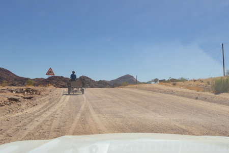 Gravel road in Namibia. A man driving a buggy.の写真素材
