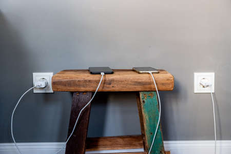 Two Smartphones Charging in a Hotel Roomの写真素材