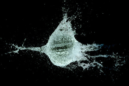 A view of a water splash with a gunshot through a balloonの写真素材