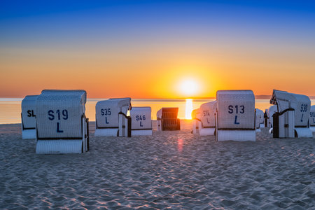 Sunrise on the beach by the Baltic Sea with beach chairs on the island of Usedomの写真素材