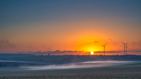 A view of a wind turbine at sunset in Allstedt in Saxony-Anhaltの写真素材