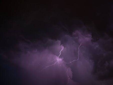 Two lightning and violet skies during thunderstorm in summer