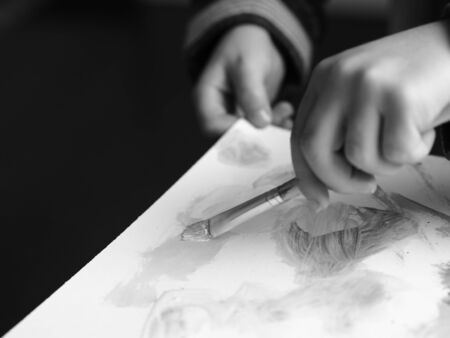 A child paints a picture with a brush and watercolor, blackandwhite picture part 3の写真素材