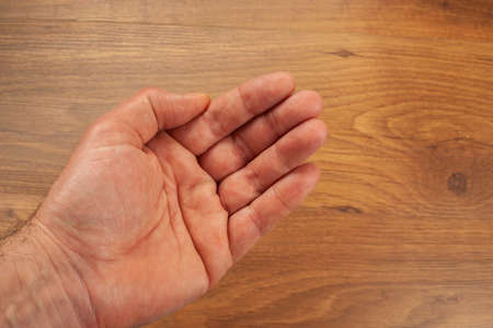 Open hand of a man isolated on a wooden surfaceの写真素材