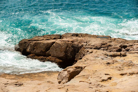 Flat rocks of the Tuscan coast with waves Italyの写真素材