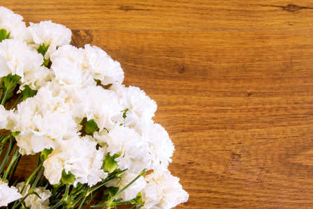 Brown wooden background with a composition of white carnationsの写真素材