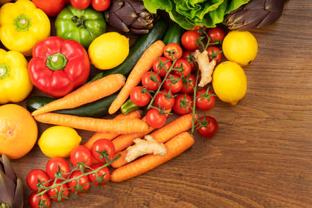 A brown wooden table with seasonal fruits and vegetablesの写真素材