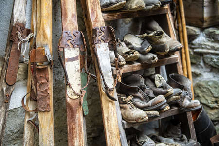 A storage with old wooden skis and mountain bootsの写真素材