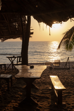 An empty wooden bar on the beach at sunsetの写真素材