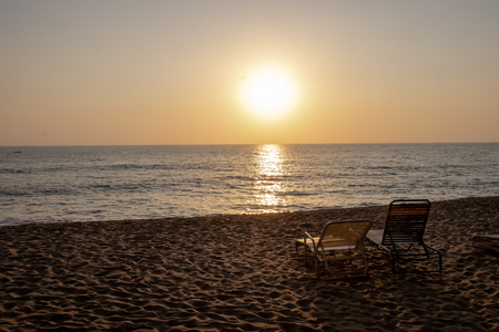Two deckchairs on the beach during a beautyful sunsetの写真素材