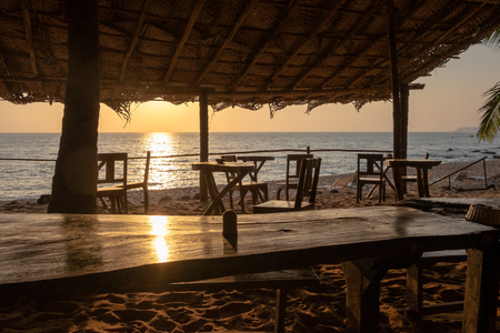 An empty wooden bar on the beach at sunsetの写真素材