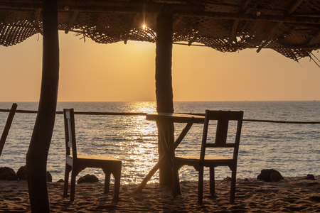 An empty wooden bar on the beach at sunsetの写真素材
