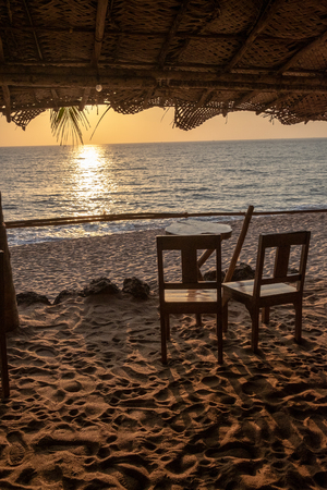 An empty wooden bar on the beach at sunsetの写真素材