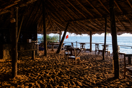 An empty wooden bar on the beach at sunsetの写真素材