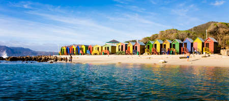 People enjoying an early morning at St James Beach, Cape Town, South Africa. This beach is known for it's colorful bathing boxesの写真素材
