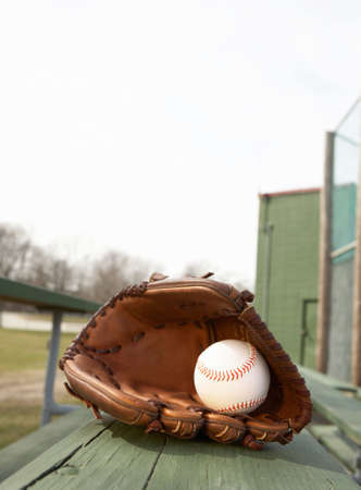 Baseball in glove on bleacher stands at ballparkの写真素材