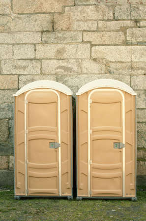 Portable toilets against stone wall subtle cross-processed colorsの写真素材