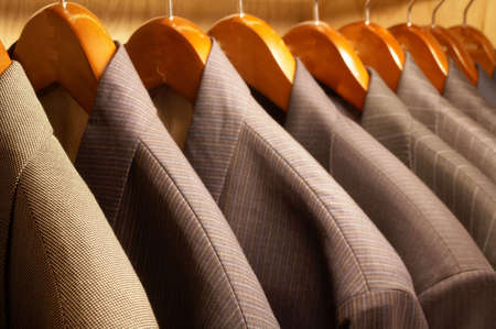 Row of men's suit jackets hanging on hangersの写真素材