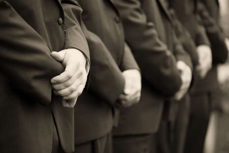 Groomsmen's hands at wedding ceremony, sepia tonedの写真素材