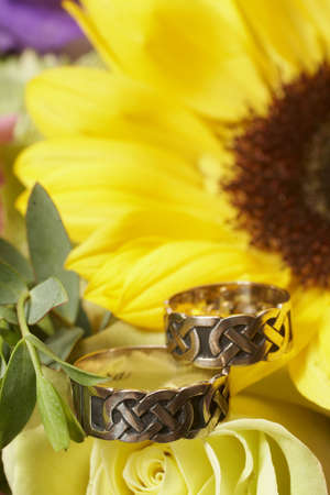 Wedding rings on yellow sunflower focus on bandsの写真素材