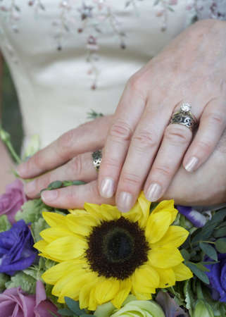 Wedding rings on hands of bride and groom, focus on handsの写真素材