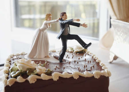 Funny wedding cake top bride chasing groomの写真素材