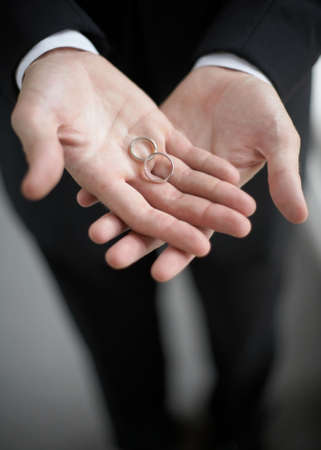 Hands holding wedding bands DOF focus on ringsの写真素材