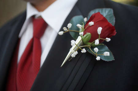 Classic red rose wedding boutonniere on suit of groom の写真素材