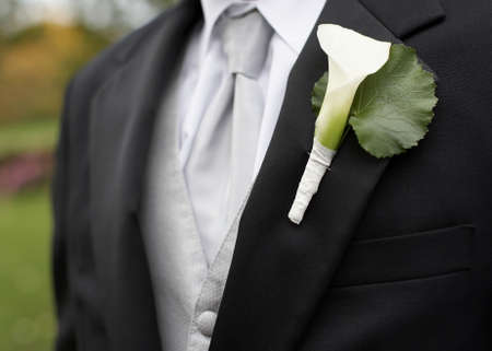 White calla lily boutonniere on suit jacket of groomの写真素材