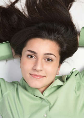 Beautiful young woman laying down looking up の写真素材