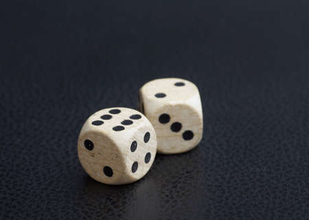 Pair of wooden dice on black leather backgroundの写真素材