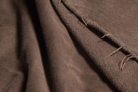 Texture of thick brown fabric with marked waves and frayed on the edgeの写真素材