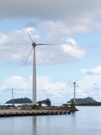 large wind turbines on background of ocean and sky and islands in the distance, Seychelles