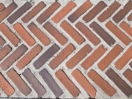 old garden path of red and brown coarse chipped bricks with thick rough seams