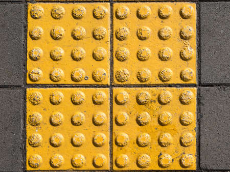yellow concrete tiles with texture on the sidewalk is for the blindの写真素材