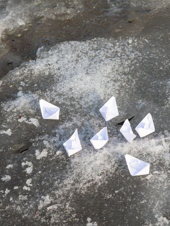 small white paper boats near the creek in early spring