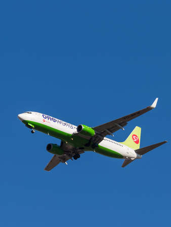 Domodedovo - March 14, 2015: A passenger plane Boeing-737, S7 Airlines, in the colors of the British flag, landing at Domodedovo airport and blue sky March 14, 2015, Domodedovo, Moscow Region, Russiaのeditorial素材
