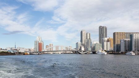 Tokyo - January 28, 2015: Urban cityscape, bridge over the river Sumida and ships sail January 28, 2015 in Tokyo, Japanのeditorial素材