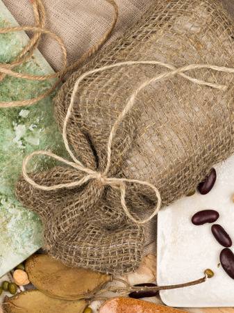 vertical bright collage of ceramic tiles in country style in different shades, tree bark, twine and legumes on natural fabricの写真素材