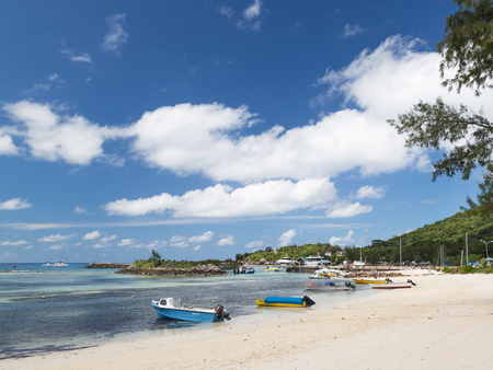 La Digue - November 9, 2014: an exotic beach and port with motor boats, yachts and ferries on the tropical island of November 9, 2014, La Digue, Seychellesのeditorial素材